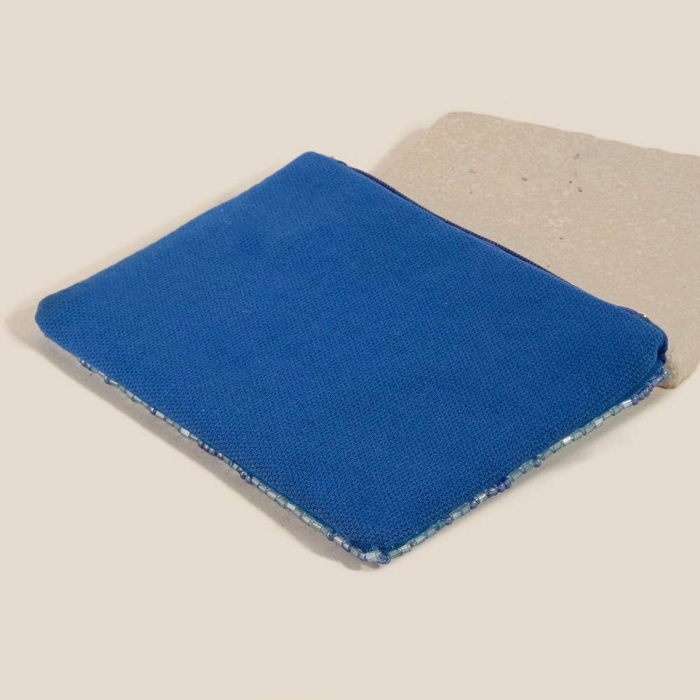 A rectangular blue cleaning sponge with coarse and smooth sides, displayed on a neutral background, evokes the vibrant look of Anarchy Street’s Blue Mahjong Money Seed Beaded Coin Purse.