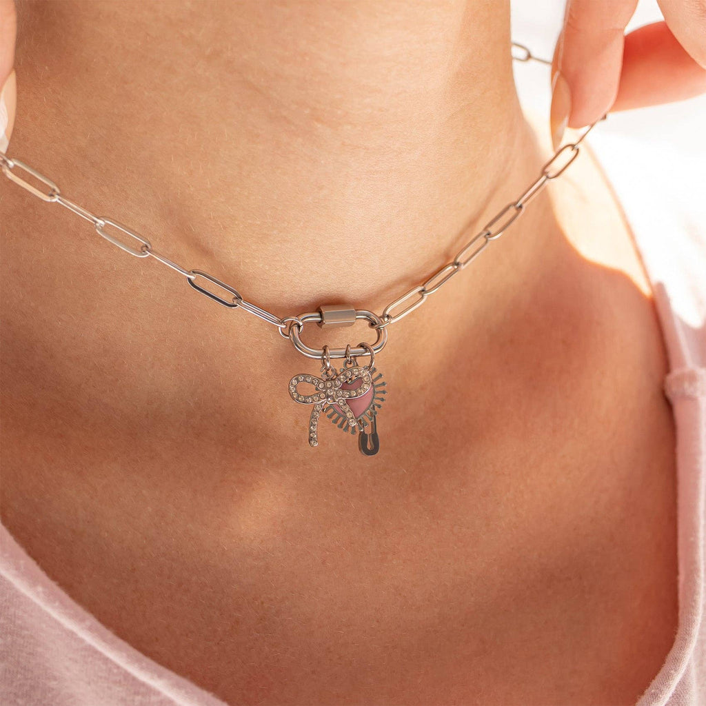 A close-up of a person wearing the WJW 18K Gold PVD Paperclip Carabiner Necklace, featuring a paperclip chain and a heart-shaped pendant adorned with rhinestones.