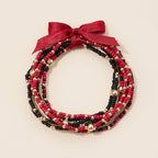 Game Day Seed Beaded Bracelet Set in red, black, and gold, tied with a red ribbon bow.