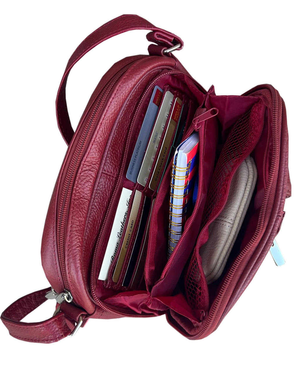 Open red cowhide leather 3013 Crossbody Bag with front organizer, featuring an adjustable shoulder strap and internal compartments holding credit cards, a small spiral notebook, and a pouch.