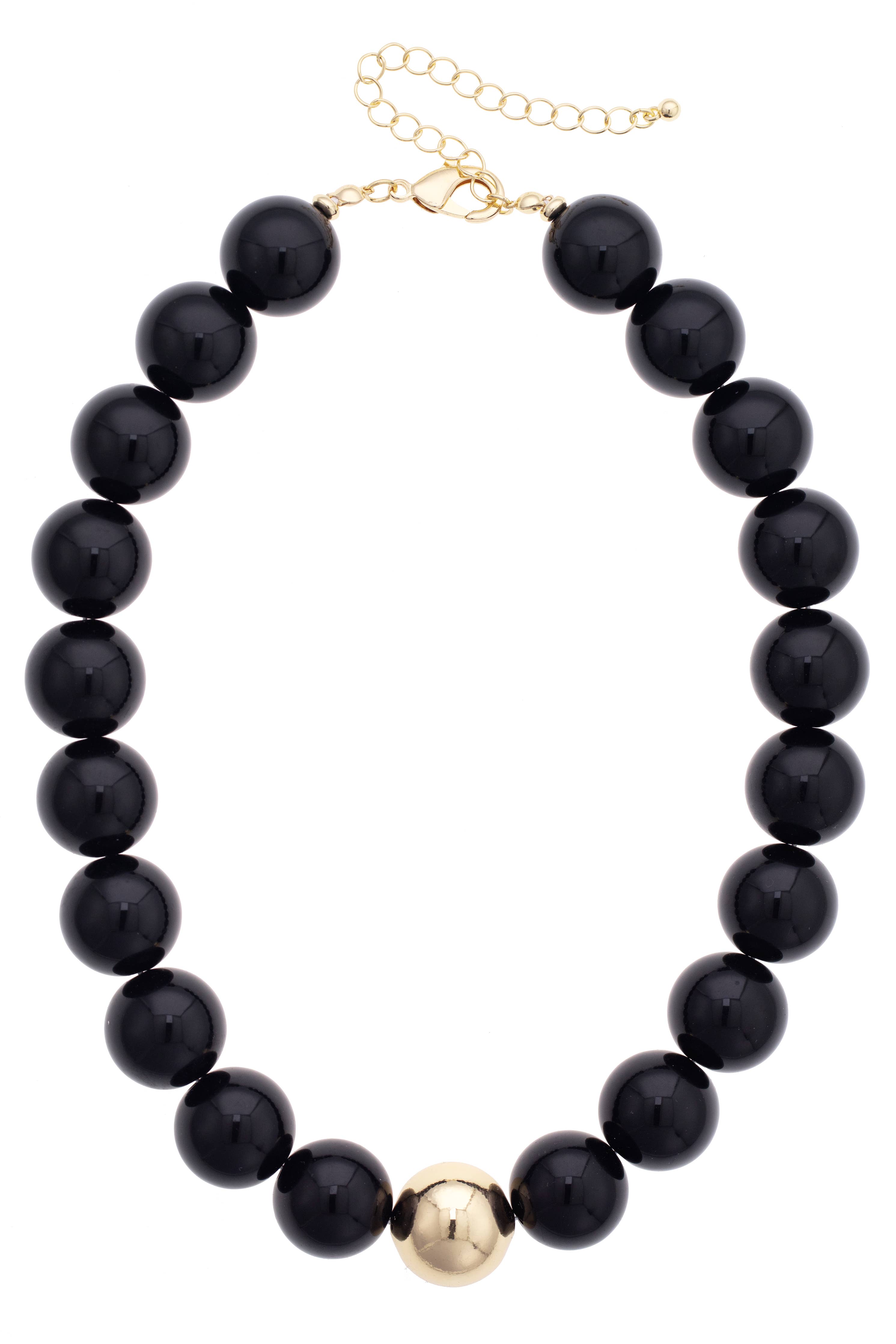 Introducing the Marjorie Game Day Beaded Necklace by Canvas Style—this statement piece features oversized black beads accented with a single gold bead at the center and is finished with an adjustable gold chain clasp. Perfect for adding bold style to any outfit!.