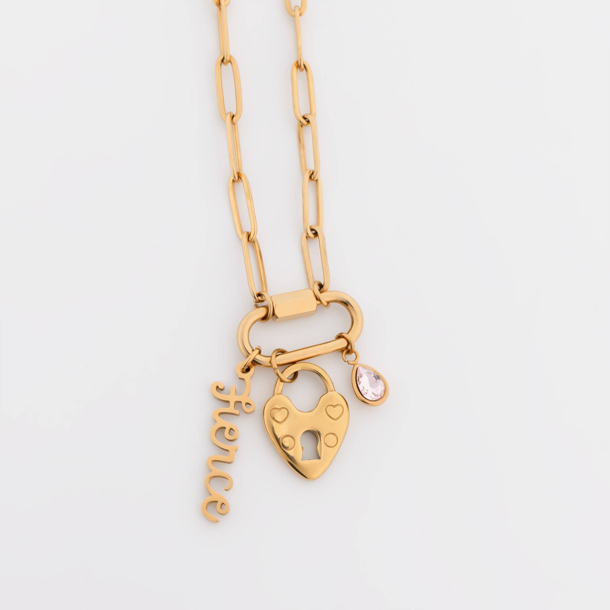 WJW 18K Gold PVD Paperclip Carabiner Necklace featuring a heart-shaped lock charm, a script "fierce" charm, and a small teardrop gemstone charm on a white background. This stylish necklace is perfect as a customizable accessory to showcase your unique style.