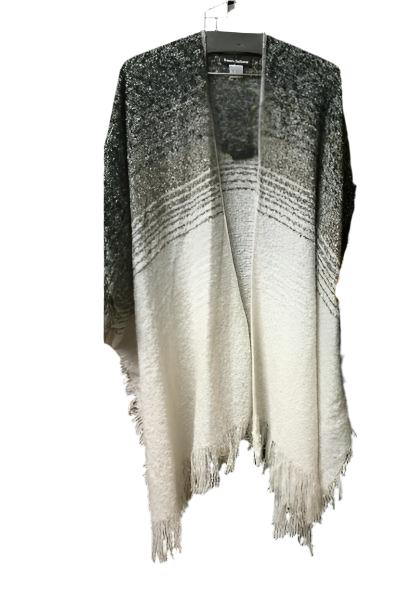 The Soft Shawl in Black and White from RONNIE SALLOWAY & CO INC hangs against a dark background, highlighting its gradient tones from dark to light. The textured fabric is enhanced by a soft fringe at the bottom, making this stylish piece an easy and delightful addition to your wardrobe.