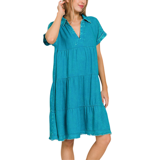 Woman in a FASHION GO Washed Linen Raw Edge V-Neck Dress in Teal posing with her hand on her head.