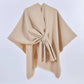 The ACCITY SIMPLE SOLID COLOR OBLIQUE STRAP CAPE SHAWL in beige wool features a tied front, ideal for layering, shown against a plain white background.