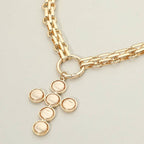 Pearl Cross Charm Pendant Chunky Chain Statement Necklace by Sensibling Corp., featuring a bold gold chain and a textured cross pendant formed from six circular elements, displayed against a light background.