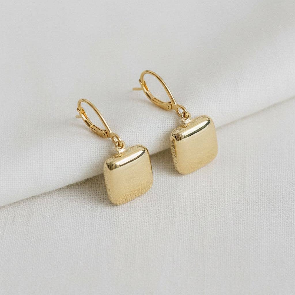 Ellemadera’s Modern Geometric Drop Earrings, featuring lever-back clasps, are showcased on a folded white fabric background—an ideal choice for those seeking elegant and minimalistic style.