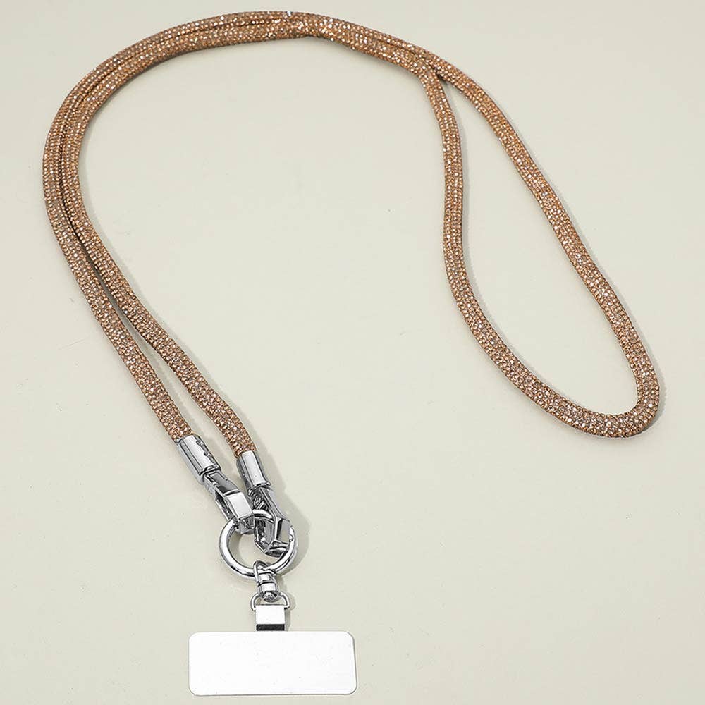 The Sensibling Corp. Rhinestone Phone Lanyard Necklace features shimmering gold beads and a sturdy metal clasp, elegantly displayed on a light surface with a blank rectangular name badge attached, and conveniently doubles as a stylish cell phone holder.