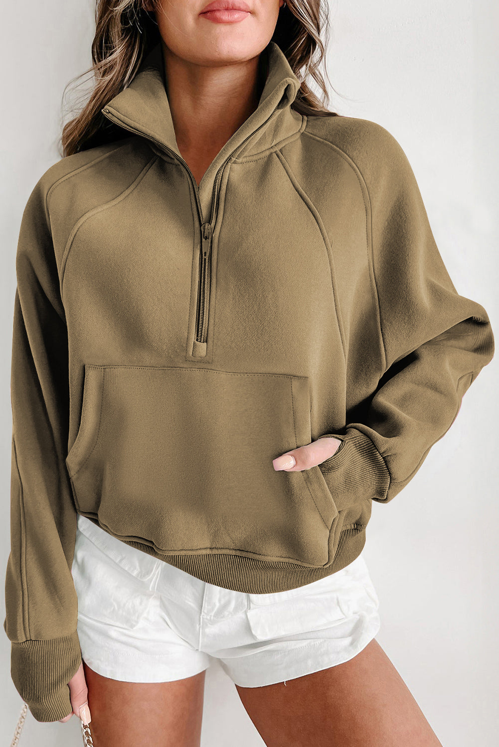 A person with long hair wears the Shewin Gray Zip Up Stand Collar Ribbed Thumbhole Sleeve Sweatshirt and white shorts against a plain background.