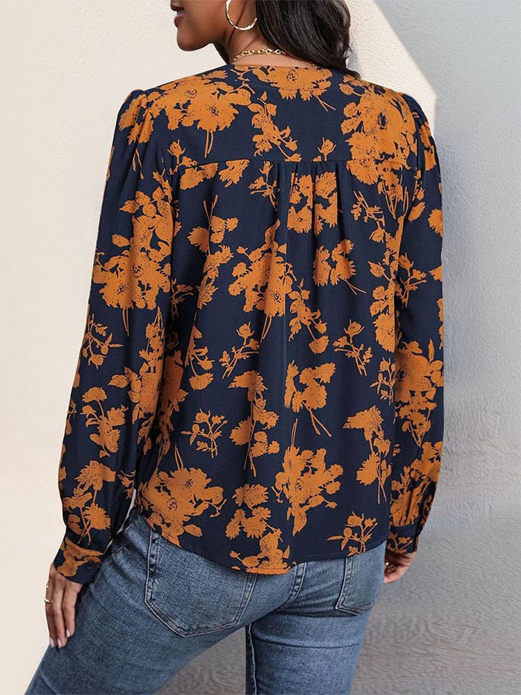 Back view of a person wearing the Navy and Orange Print Pull Over Blouse, a long-sleeved navy blue fall top with a repeating orange floral print.