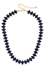 The Marseille Resin Beaded Necklace features adjustable round, dark blue resin beads alternating with small gold-tone spacers, finished with a gold-tone lobster clasp and extender chain.