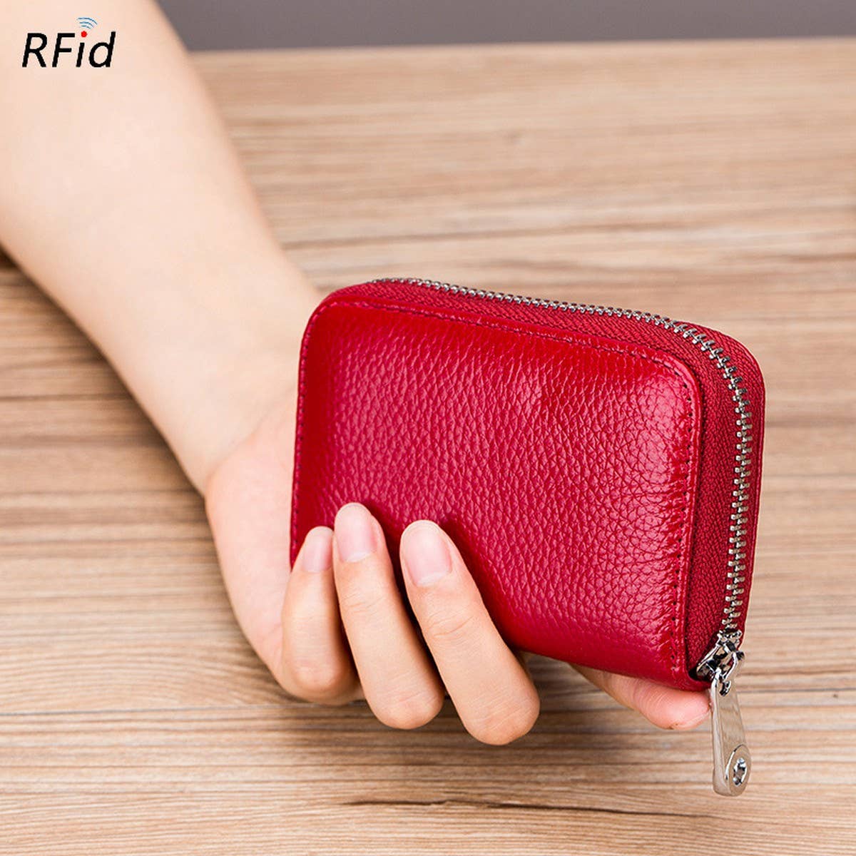 A hand holds the ACCITY CARD WALLET Anti-Theft Wallet, a compact red leather wallet with RFID protection and a secure zippered closure.