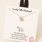 Gold dipped elephant pendant necklace from FASHION GO displayed on a card labeled "lucky little elephant" with a message of good wishes, against a light background.