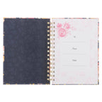 Open Journal Spiral-bound Be Still Ps. 46:10 with a dark floral inner cover on the left and a page featuring pink roses with spaces for “To,” “From,” and “Date” on the right.