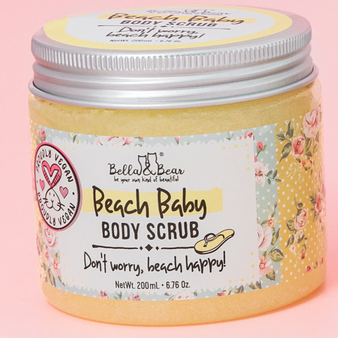 A 6.7oz jar of Bella & Bear Beach Baby Body Scrub, Body Wash & Moisturizer with a floral label sits on a pink background, inviting you to enjoy a beach glow and tropical escape with every vegan-friendly use.