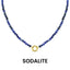 A Semi Precious Natural Stone Charm Keeper Necklace by WJW, featuring round blue sodalite beads and a central 18K Gold PVD Coated clasp, is displayed against a white background. Below the necklace, the word "SODALITE" appears.