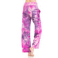 A person stands barefoot against a white background, shown from the back, wearing Leggings Depot Buttery Soft Print Pajama Pants—loose-fitting with pockets in a purple and pink tie-dye design.