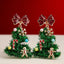 Adorn your holiday look with the Tinsel Christmas Tree Drop Earrings by Lilla Haven—festive ornament charm earrings shaped like Christmas trees and beautifully embellished with red bows, candy canes, gingerbread men, snowflakes, and colorful beads. Set against a cheerful red and beige backdrop, these earrings are the perfect sparkling accessory for any festive ensemble.