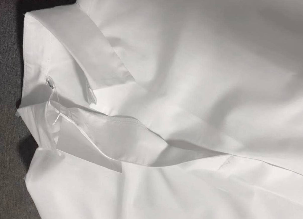 Close-up of the FASHION GO White Relaxed Fit Short Sleeve Blouse laid flat, showcasing its attached collar tag—an essential wardrobe piece that transitions seamlessly from a formal to a casual look.