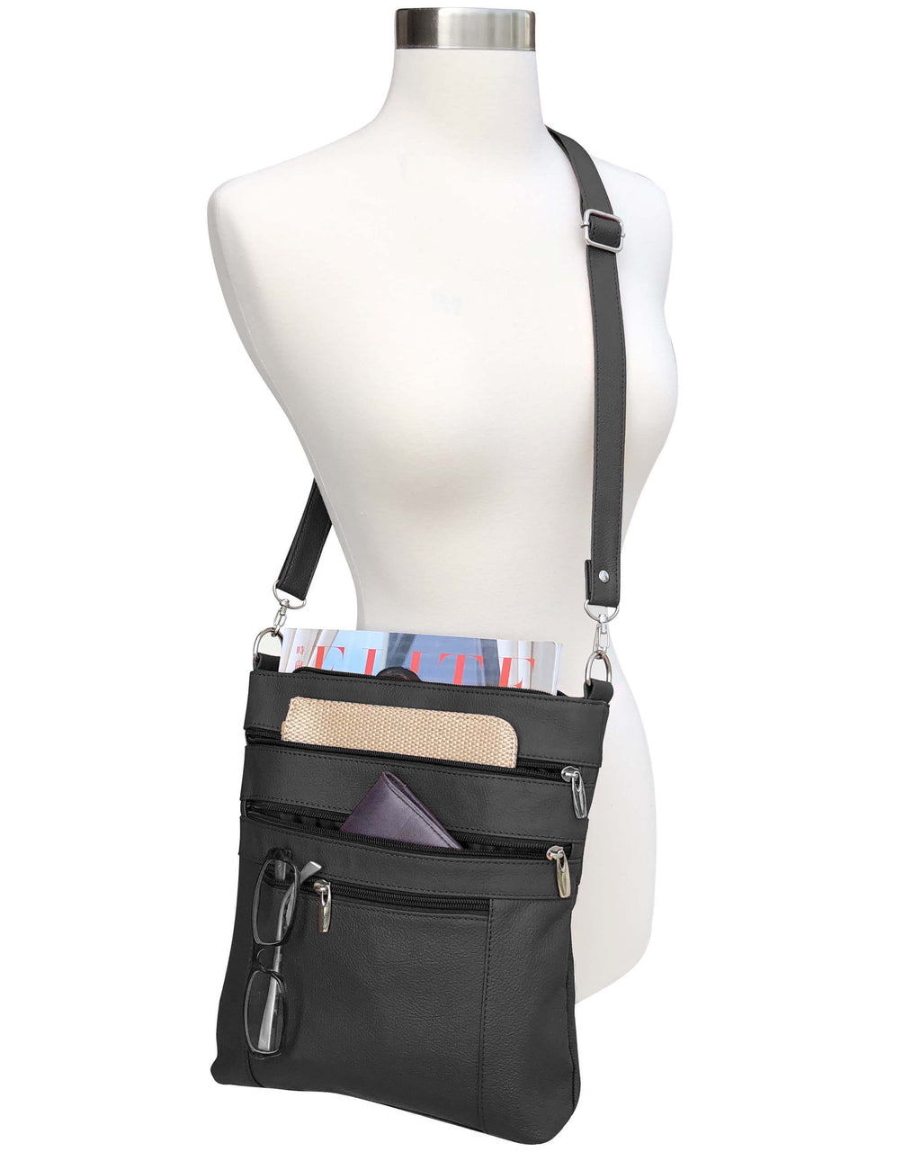 The Roma Leathers, Inc. Cowhide leather crossbody is shown on a mannequin, featuring adjustable shoulder strap and multiple zippered pockets that hold a magazine, wallet, glasses, and pens.