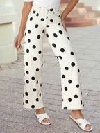 A person wears 1 the Woman Polka Dot Print Straight Leg Casual Pants, featuring large black dots, paired with a white top and white sandals on a paved outdoor path.