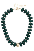 Make a statement with the Canvas Style San Sebastián Beaded Resin Necklace, featuring large, round, dark green resin beads accented by a single central gold bead. This short gold necklace is finished with a lobster clasp and extender chain for adjustable length.