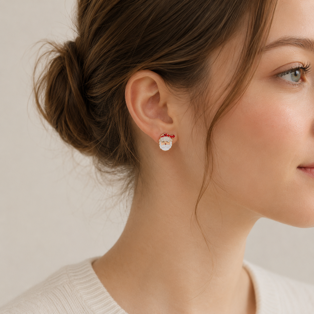 A woman models the Lilla Haven Santa Claus Stud Earrings | Red Rhinestone Christmas Earrings, shown from the side with her hair tied back against a neutral background—a delightful piece of holiday jewelry perfect for the season.