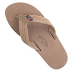 The Mens' Rainbow Single Layer Leather Flip-flops by RAINBOW SANDALS feature a tan nubuck leather footbed, comfortable single-layer arch support, a fabric strap, and a small rainbow logo tag on the side.