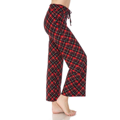 A person stands barefoot in side view, one foot slightly raised, wearing Leggings Depot Buttery Soft Print Pajama Pants with an elastic waistband.