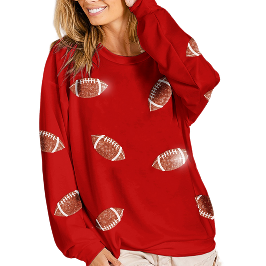 A woman smiles while wearing a FASHION GO Sequin Football Sweatshirt in Red adorned with sequined football graphics.