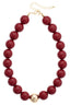 Make a bold impression with the Marjorie Game Day Beaded Necklace from Canvas Style—this eye-catching statement piece features oversized maroon beads accented by a single central gold bead, complete with a gold clasp and adjustable chain. Perfect for anyone who loves chunky beaded necklaces and striking style.
