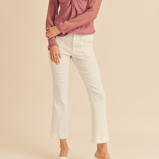 The model is wearing FASHION GO's Patch Pocket Mid-Rise Cropped Flare Stretch Pant in White.