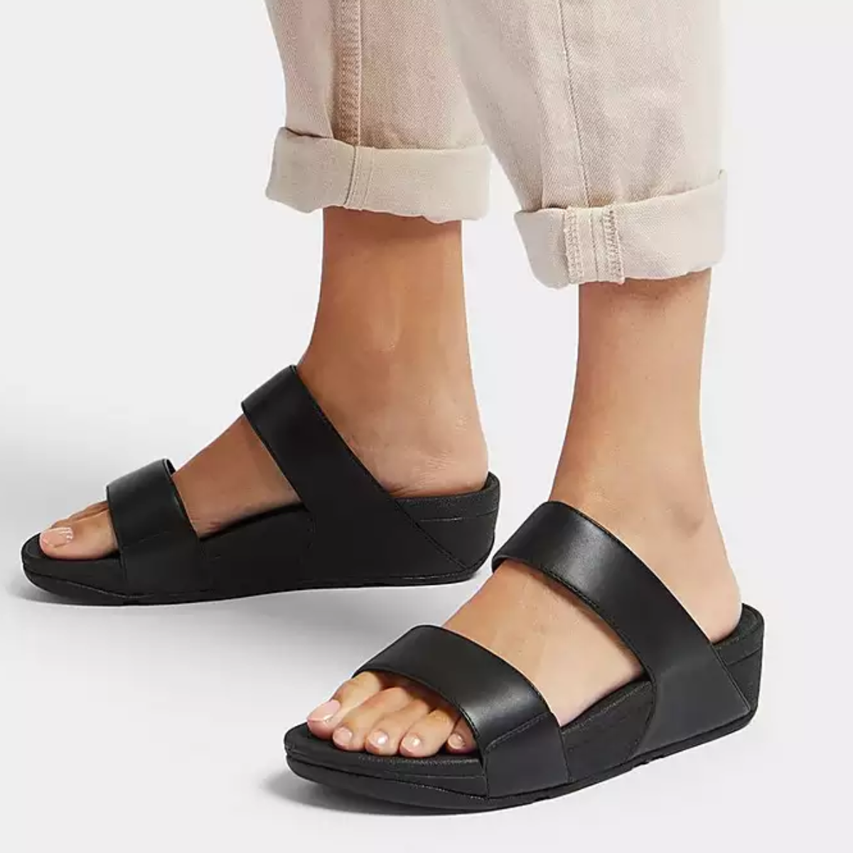 A woman's Lulu Adjustable Leather slide in Black sandals by Flipflops & Whatnots.