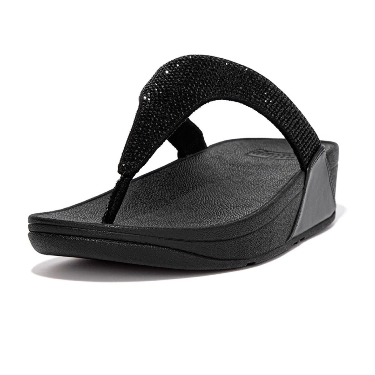 The Lulu Crystal Embellished Toe Post Flip Flop in Black by FIT FLOPS, presented from a side angle, showcases textured straps and footbed. It features FITFLOP's signature Microwobbleboard™ midsoles for enhanced comfort and style, adorned with subtle micro-crystals.
