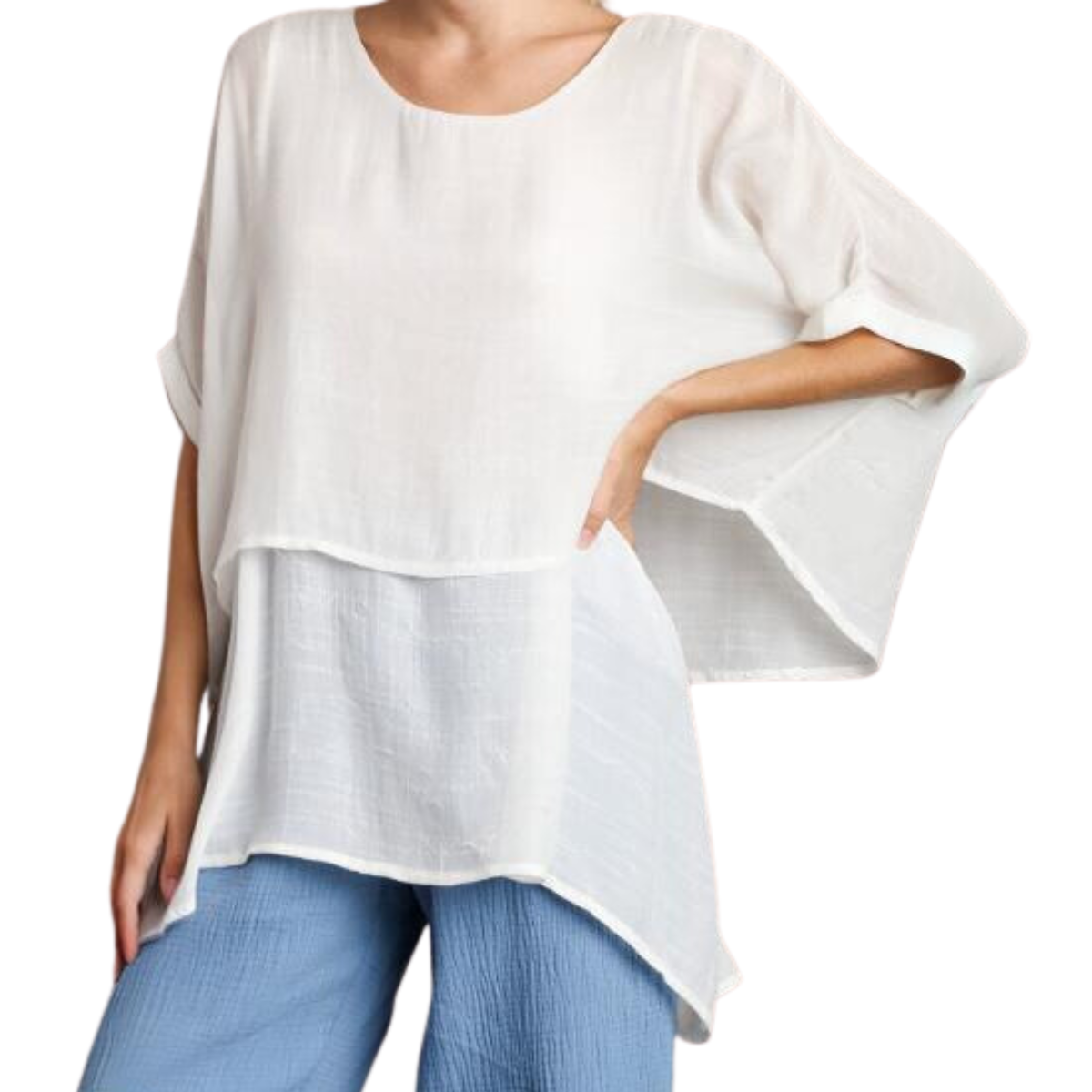 A person wearing a white, Cuffed 1/2 Sleeve Layered Tunic by Umgee with an asymmetrical hem, paired with blue jeans.
