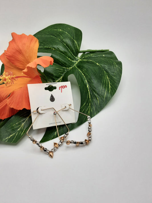 A pair of URBANISTA EW7007 ASSORTED beaded hoop earrings by Fashion Go sits on a white background adorned with a tropical leaf and an orange flower. A white tag featuring a black droplet icon and "290" in red indicates the price.