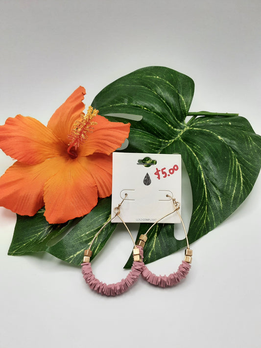 A pair of URBANISTA EW7339 ASSORTED pink beaded hoop earrings from Fashion Go on a white card featuring "$5.00" in red, beautifully arranged with green leaves and an orange hibiscus flower in the background.