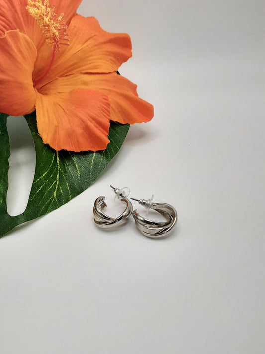 A pair of CITY 9761 MULTI earrings by SPECIAL EFFECTS is placed on a white surface next to an orange hibiscus flower.