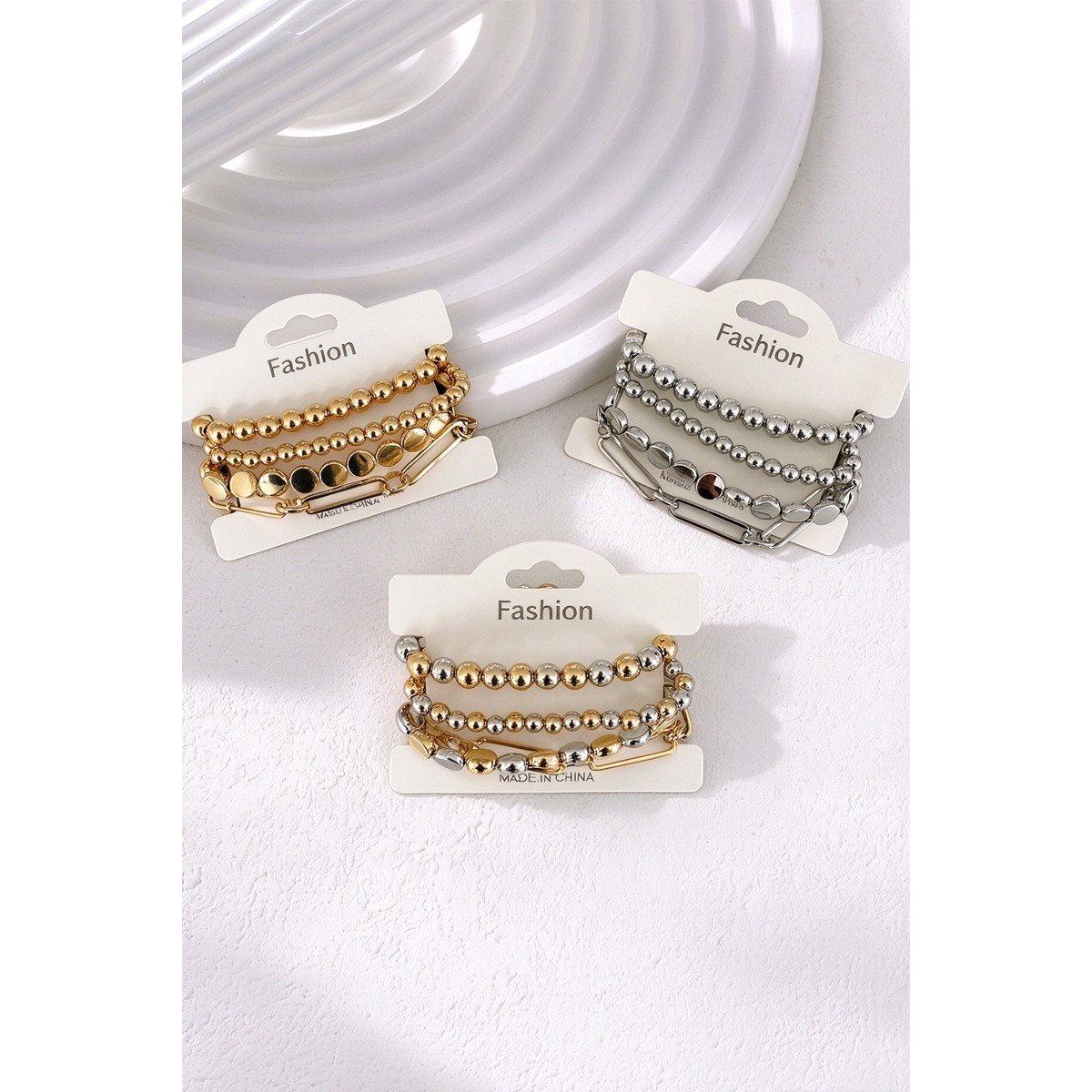 Gold, Silver, and Multi four-piece bracelet sets on display cards