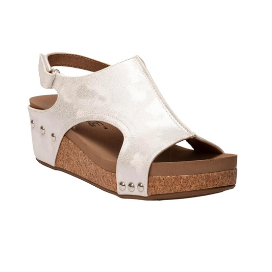 Volta Low Wedge Sandal in White Metallic by CORKY'S FOOTWEAR INC, with a cork platform, open toe design, and ankle strap closure, isolated on a white background.