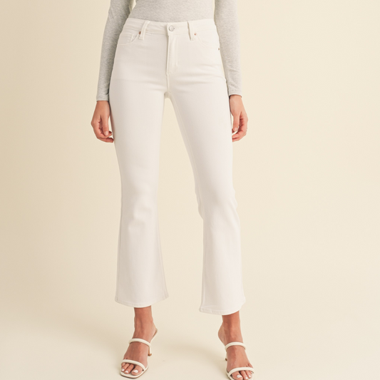 A person wearing FASHION GO's Petite Boot Cut White Jeans by Just USA (Just Black Denim) and white sandals against a neutral background.