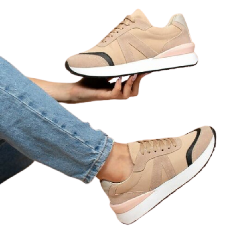 A woman's hand holding a pair of MAKERS Nova in Tan sneakers.