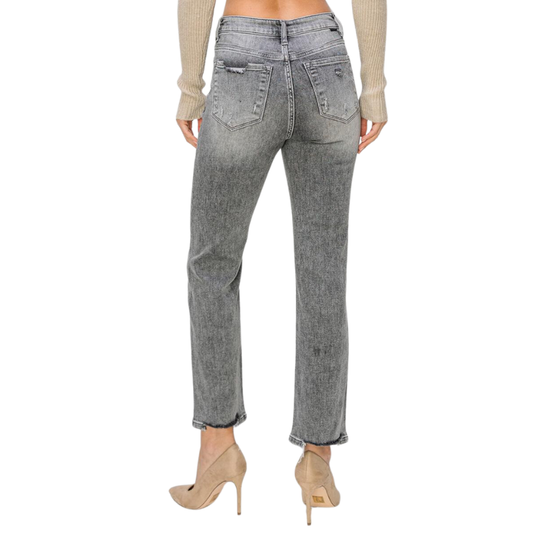 The woman's back view showcases her RISEN HIGH RISE CROP STRAIGHT JEANS in grey with a worn-in look.